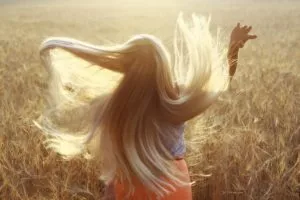 Fettige Haare: Frau mit blonden langen Haaren im Sommer