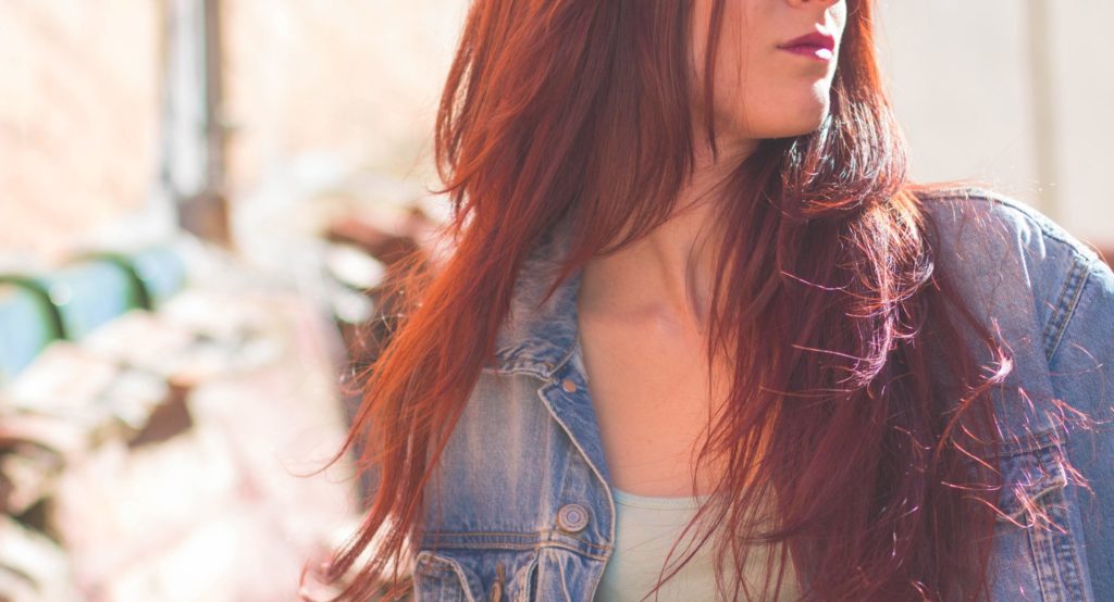 Verfilzte Haare pflege: Junge Frau mit langen, roten gefärbten Haaren